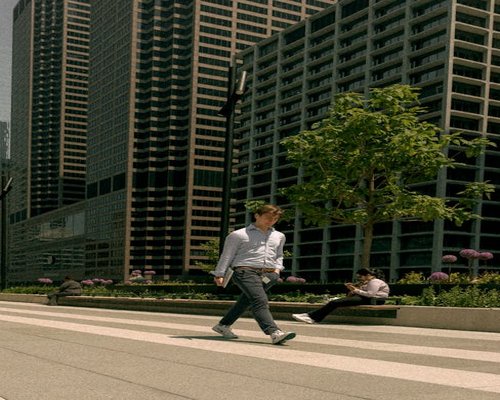 A person walking comfortably outdoors near an office building