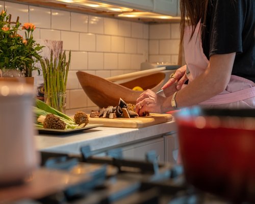 Person preparing healthy food in a home kitchen, displaying relaxed posture